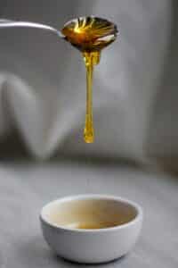 Raw honey dripping from spoon into bowl showing natural texture and viscosity