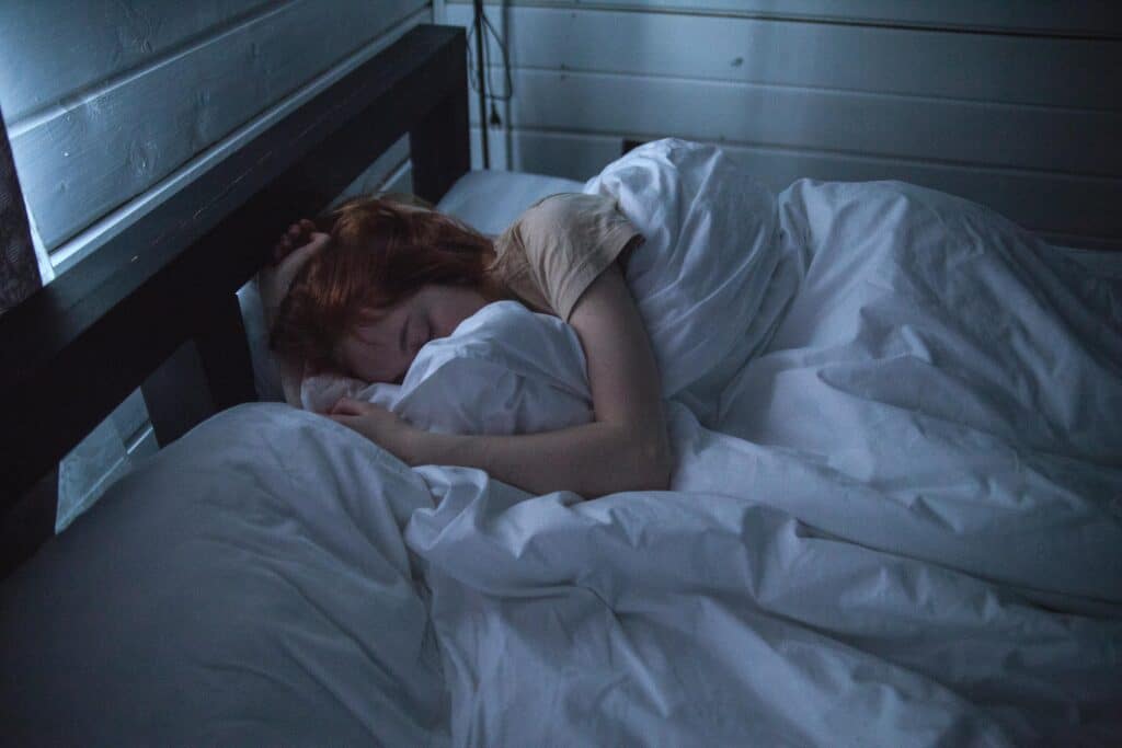 Person sleeping peacefully in bed at night representing restful sleep