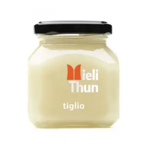 Jar of pale Meili Thun Linden Honey labeled “tiglio,” with a black lid, on a white background.