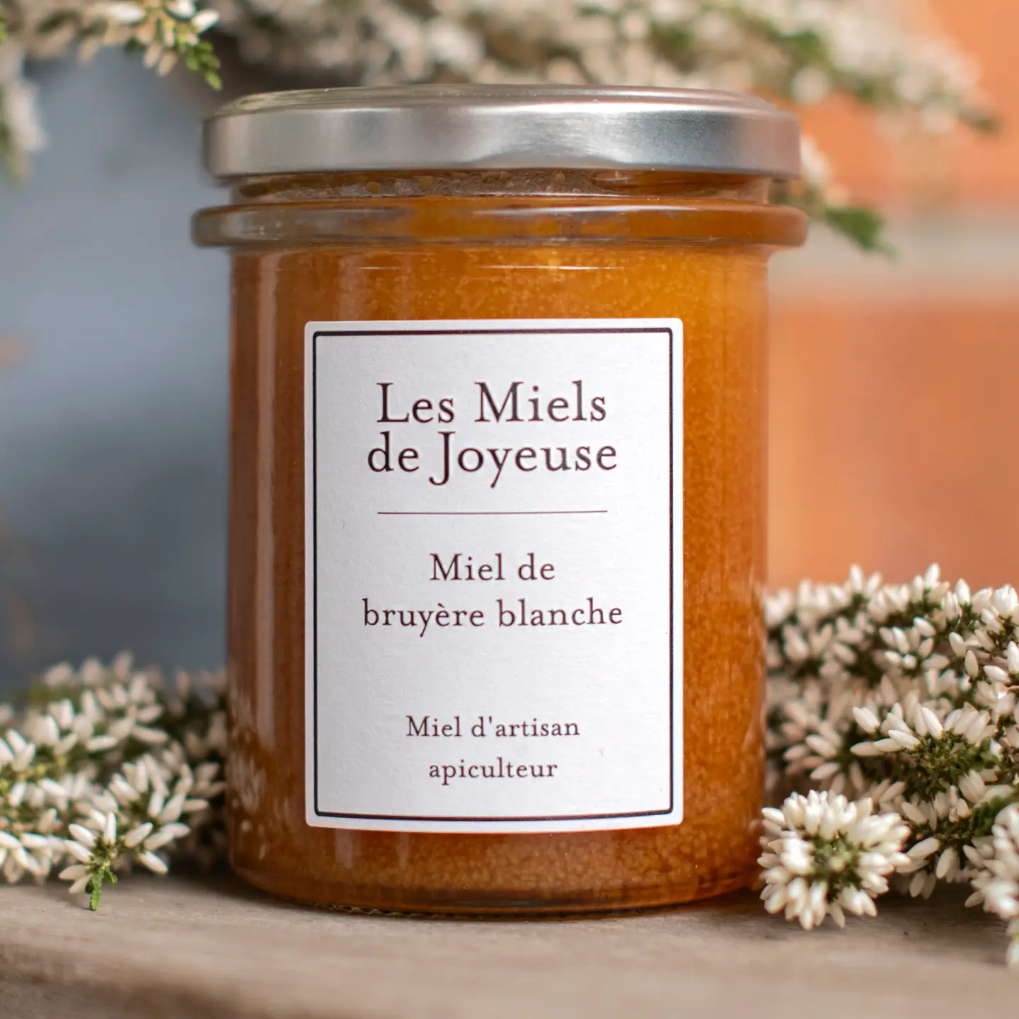Les Miels de Joyeuse White Heather Honey surrounded by white heather flowers