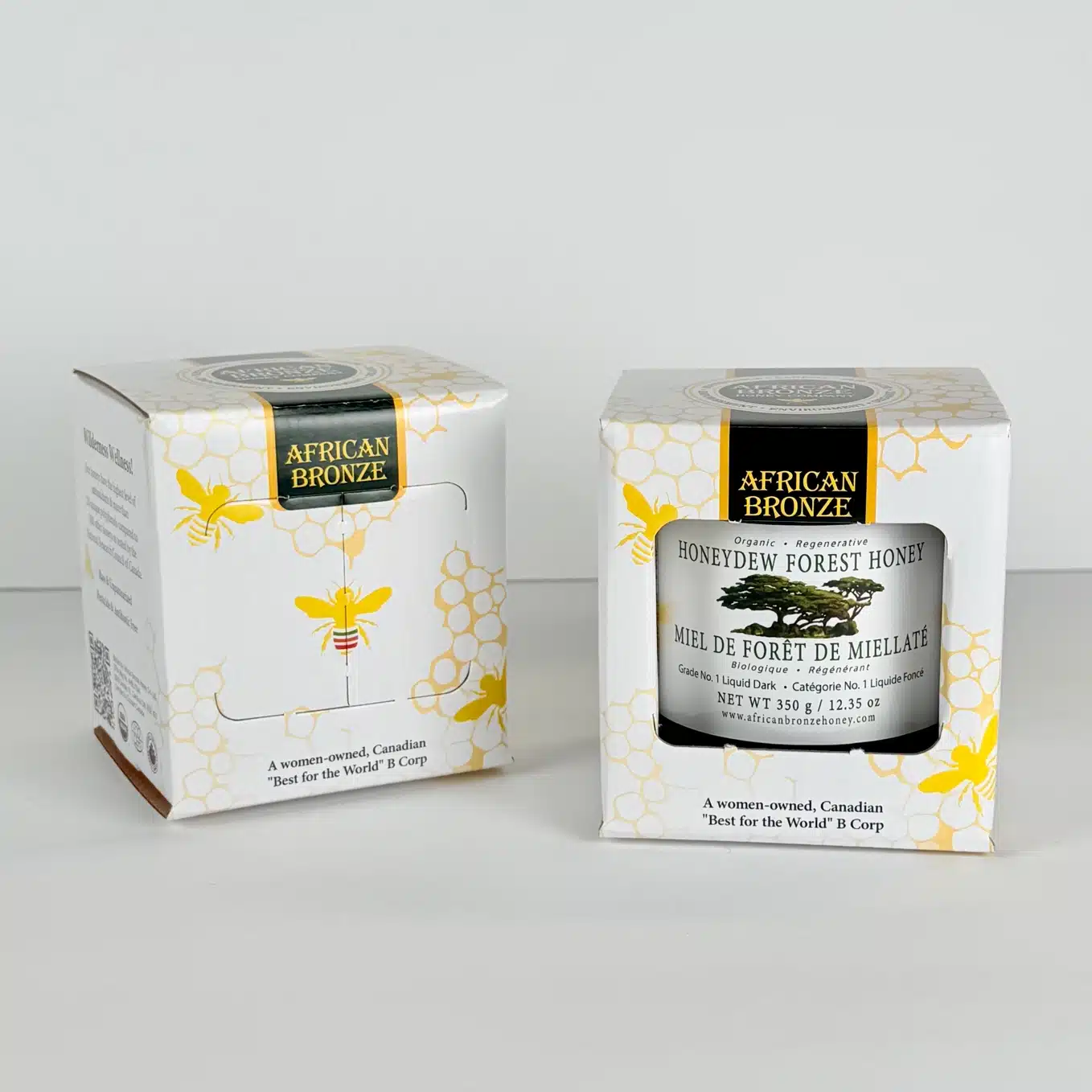 Two boxes of African Bronze Honeydew Forest Honey on a white background